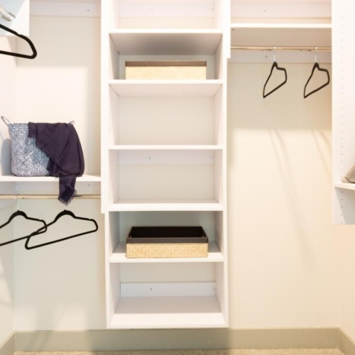 a white shelving unit with a shelf and a bed