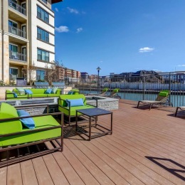 a deck with chairs and tables on it by a body of water
